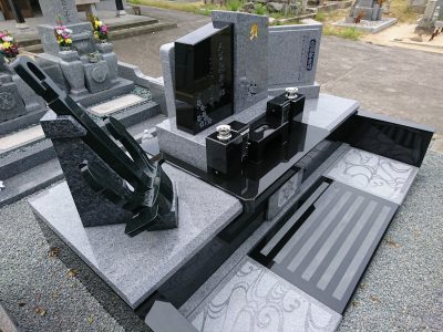 イカリのオブジェが飾られた庵治石と黒御影石の玉垣一体型現代墓